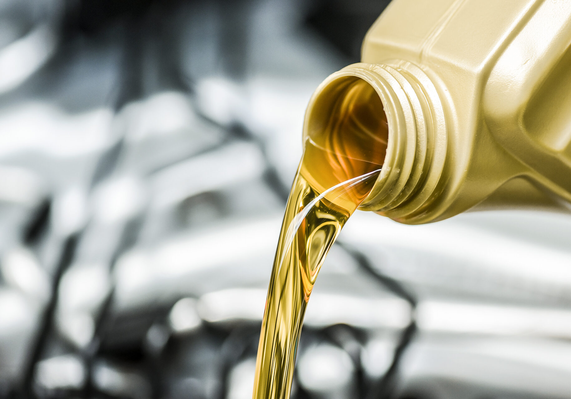 Woman hand pour motor oil to car engine. motor oil